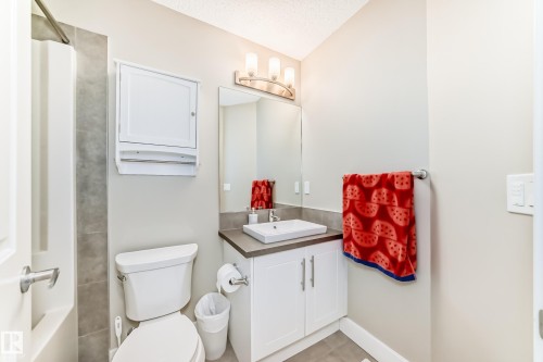 Bathroom featuring a white vanity with a rectangular basin sink, a gray countertop, and built-in storage cabinetry - 2125 24 Street, Edmonton, AB - Indoor Photo Showing Bathroom