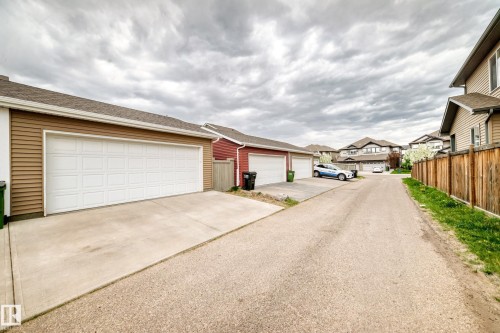 Two-car garage with white panel doors and tan horizontal siding - 2125 24 Street, Edmonton, AB - Outdoor
