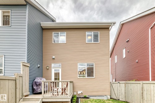 Rear exterior featuring tan horizontal siding and white trim - 2125 24 Street, Edmonton, AB - Outdoor With Deck Patio Veranda With Exterior