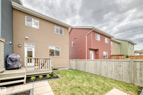 Rear exterior featuring a wooden deck with railing, direct yard access, and exterior lighting - 2125 24 Street, Edmonton, AB - Outdoor With Deck Patio Veranda With Exterior