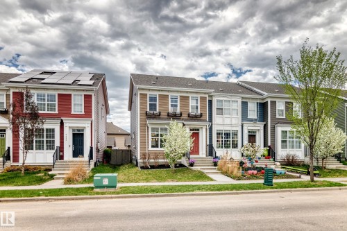Red siding exterior with white trim, featuring solar panels on the roof - 2125 24 Street, Edmonton, AB - Outdoor With Facade