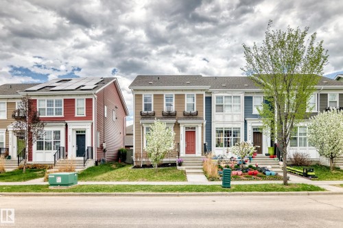 Modern townhome with solar panels, multi-pane windows, and a black front door - 2125 24 Street, Edmonton, AB - Outdoor With Facade