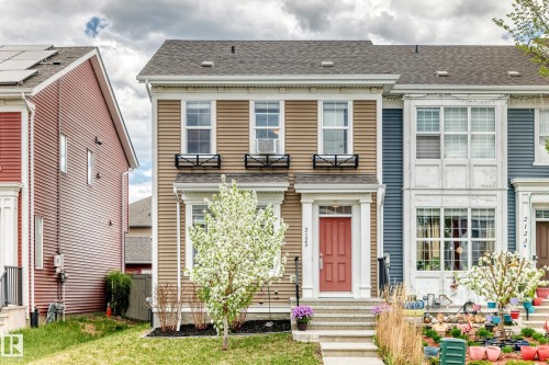 Two-story townhouse with beige horizontal siding and a dark shingle roof - 2125 24 Street, Edmonton, AB - Outdoor With Facade