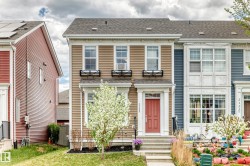 Two-story townhouse with beige horizontal siding and a dark shingle roof - 