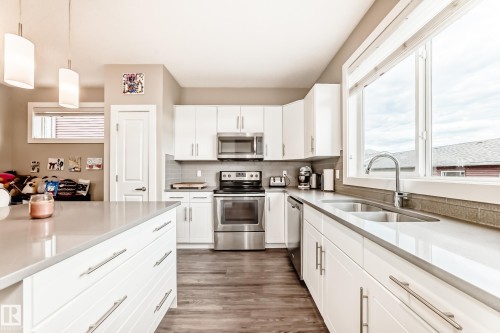 Contemporary kitchen featuring white cabinetry, stainless steel appliances, and a double basin sink - 2125 24 Street, Edmonton, AB - Indoor Photo Showing Kitchen With Stainless Steel Kitchen With Double Sink
