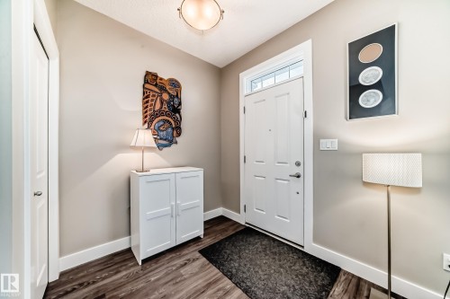 Entryway featuring wood-finish flooring, a white paneled door with a transom window, and a built-in closet - 2125 24 Street, Edmonton, AB - Indoor Photo Showing Other Room