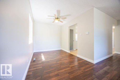 Spacious interior room featuring wood-finish flooring, light-toned walls, and white trim - 8714 164 Street, Edmonton, AB 