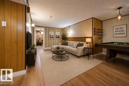Recreation room featuring wood-finish flooring, wood paneling, and a full-size billiard table. Virtually Staged Photo. - 8714 164 Street, Edmonton, AB 