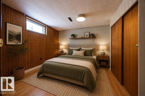 Bedroom featuring wood-finish flooring and a horizontal window. Virtually Staged Photo. - 8714 164 Street, Edmonton, AB 