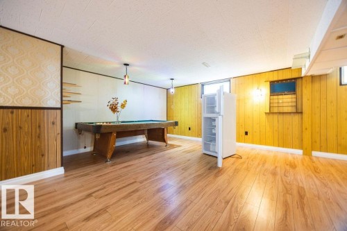 Spacious lower level featuring wood-finish flooring, recessed lighting, and a pool table - 8714 164 Street, Edmonton, AB 