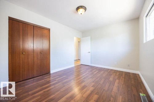 Room featuring wood-finish flooring, light-toned walls, and white baseboards - 8714 164 Street, Edmonton, AB 