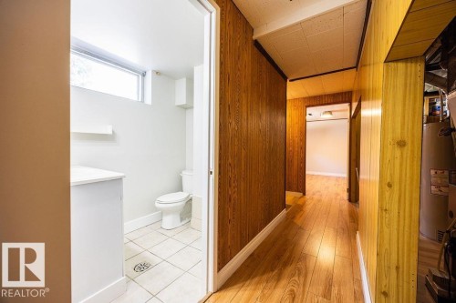 Hallway featuring wood-panel walls and wood-finish flooring - 8714 164 Street, Edmonton, AB 