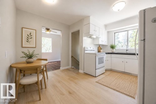 Bright kitchen with white cabinetry and dark countertops. Photo Virtually Staged. - 8714 164 Street, Edmonton, AB 