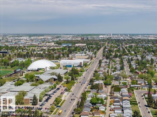 Aerial perspective showcasing a residential area with varied housing styles, mature trees, and institutional buildings - 8714 164 Street, Edmonton, AB 