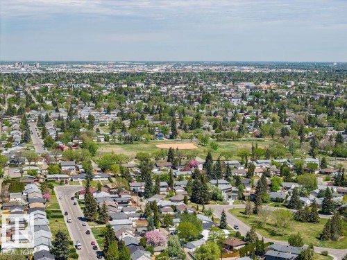 Expansive neighborhood featuring a large central park with a baseball diamond, extensive tree canopy, residential homes, and a distant city skyline - 8714 164 Street, Edmonton, AB 