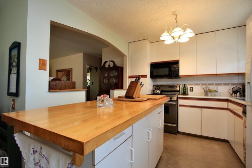 Kitchen island with oak butcher block top. - 13315 136 Street, Edmonton, AB - Indoor Photo Showing Kitchen