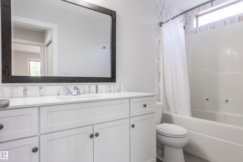 Bathroom featuring a white vanity with integrated sink, chrome faucet, and quartz countertop - 738 Kananaskis Drive, Devon, AB - Indoor Photo Showing Bathroom