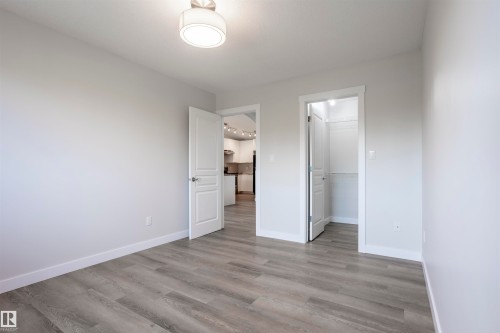 Room featuring light gray wood-finish flooring, white baseboards, and neutral wall paint - 738 Kananaskis Drive, Devon, AB - Indoor Photo Showing Other Room