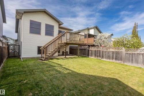 Expansive backyard featuring a wood privacy fence, a multi-level wood deck, and a lower-level patio area - 738 Kananaskis Drive, Devon, AB - Outdoor