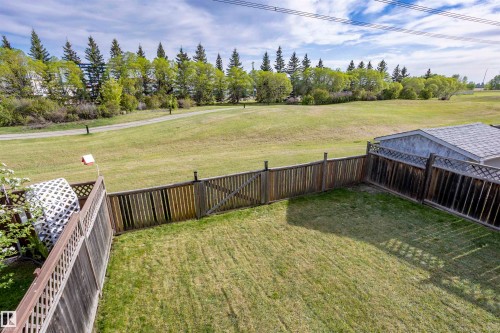 Fenced backyard with expansive green space beyond - 738 Kananaskis Drive, Devon, AB - Outdoor