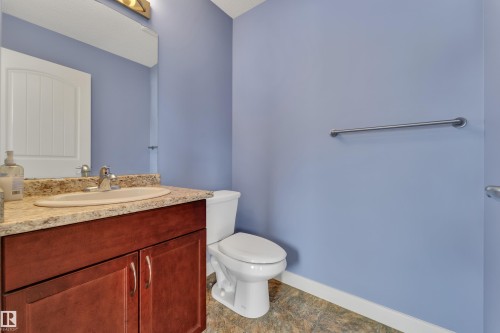 Vanity with wood-finish cabinetry, light-toned countertop, and integrated sink - 432 Watt Boulevard, Edmonton, AB - Indoor Photo Showing Bathroom