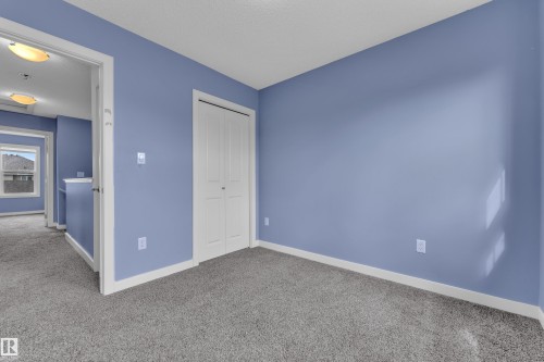 Soft blue wall paint with crisp white trim, plush gray carpeting, and a bi-fold closet door - 432 Watt Boulevard, Edmonton, AB - Indoor Photo Showing Other Room
