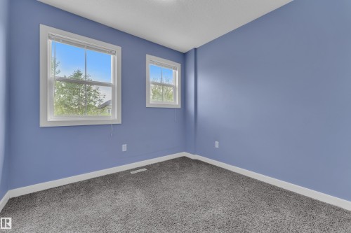 Room featuring two windows with white trim, light blue walls, and gray carpet flooring - 432 Watt Boulevard, Edmonton, AB - Indoor Photo Showing Other Room