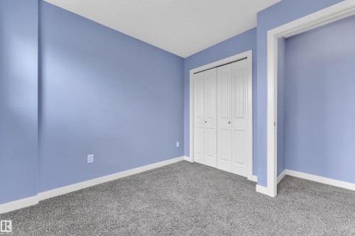 Room featuring light blue walls, gray carpet, white baseboards, and a white bi-fold closet door - 432 Watt Boulevard, Edmonton, AB - Indoor Photo Showing Other Room