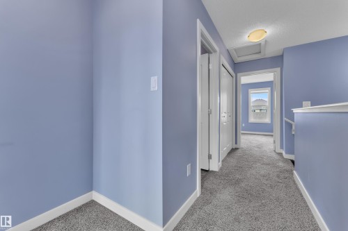 Carpeted hallway featuring light blue walls, white trim, and a flush-mount ceiling light fixture - 432 Watt Boulevard, Edmonton, AB - Indoor Photo Showing Other Room