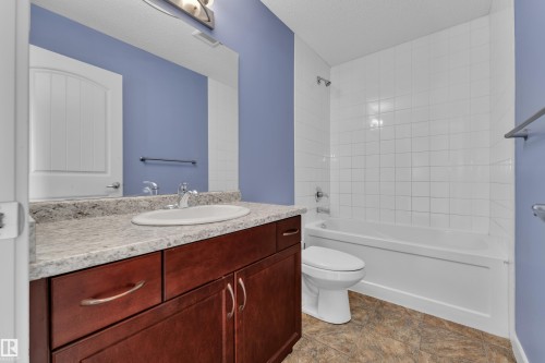 Bathroom featuring a dark wood-finish vanity with an oval undermount sink, a light-toned countertop, and a full-width wall mirror - 432 Watt Boulevard, Edmonton, AB - Indoor Photo Showing Bathroom
