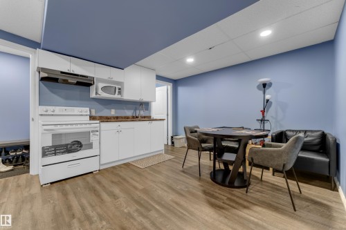 Compact kitchen area featuring white cabinetry, a built-in microwave, and a white electric range with overhead ventilation - 432 Watt Boulevard, Edmonton, AB - Indoor