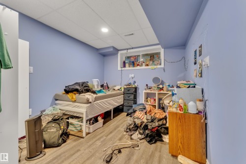Room featuring wood-finish flooring, a drop ceiling with recessed lighting, and a window with a white frame - 432 Watt Boulevard, Edmonton, AB - Indoor