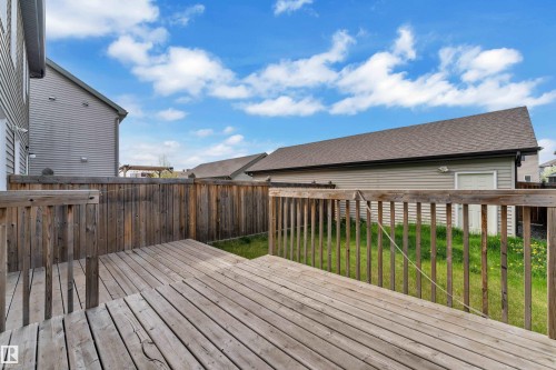 Expansive outdoor deck with natural wood railing, leading to a fenced backyard featuring a detached garage - 432 Watt Boulevard, Edmonton, AB - Outdoor With Deck Patio Veranda With Exterior