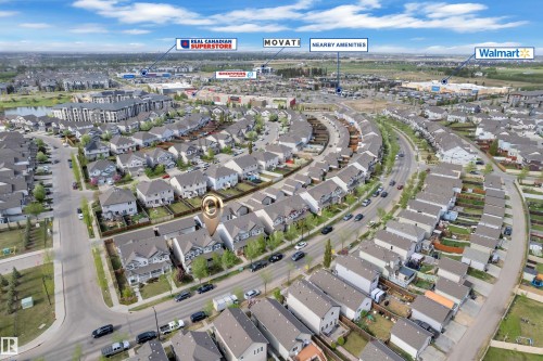 Aerial perspective showcasing a residential development with curved street planning, mature trees, and a variety of detached and attached housing styles - 432 Watt Boulevard, Edmonton, AB - Outdoor With View
