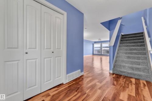 Hardwood-finish flooring extending into a spacious room with multiple windows - 432 Watt Boulevard, Edmonton, AB - Indoor Photo Showing Other Room