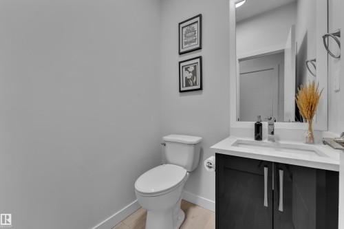 Bathroom vanity featuring dark wood-finish cabinetry, a white countertop, and an integrated sink - 1118 Goldfinch Crescent, Edmonton, AB - Indoor Photo Showing Bathroom
