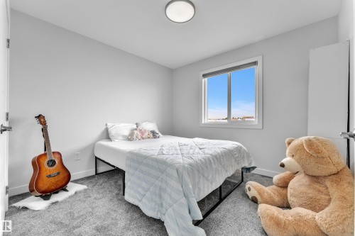 Bedroom featuring light gray walls, gray carpet, and a window with white trim - 1118 Goldfinch Crescent, Edmonton, AB - Indoor Photo Showing Bedroom