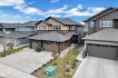 Modern two-story residence featuring a combination of horizontal and vertical siding, a stone facade, and a dark shingle roof - 1118 Goldfinch Crescent, Edmonton, AB  - Outdoor With Facade 