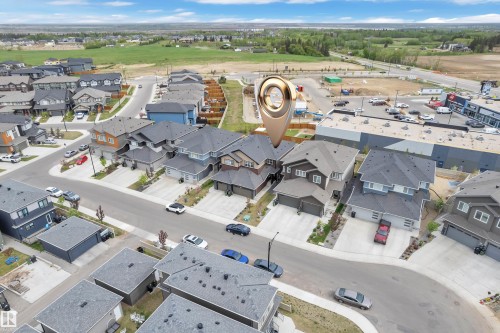 Aerial perspective of a contemporary residential neighborhood featuring individual homes with attached garages, paved driveways, and manicured landscaping - 1118 Goldfinch Crescent, Edmonton, AB - Outdoor With View