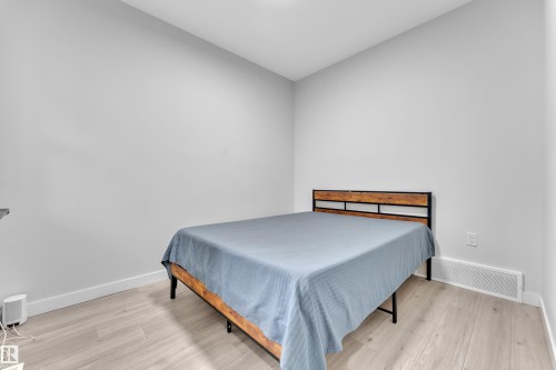 Light-colored wood-finish flooring complements the neutral wall tones - 1118 Goldfinch Crescent, Edmonton, AB - Indoor Photo Showing Bedroom