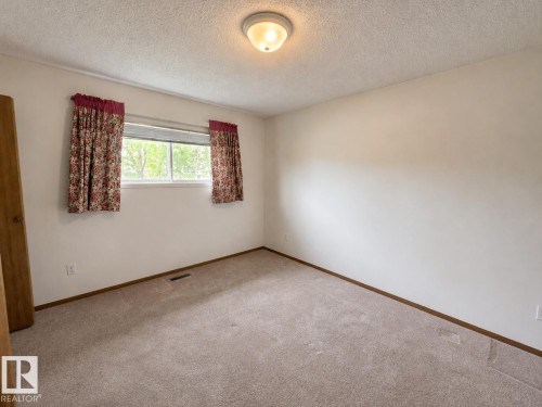 Carpeted room featuring a white wall finish, a double-pane window, and a flush-mount ceiling light - 4005 55 Avenue, Whitecourt, AB - Indoor Photo Showing Other Room