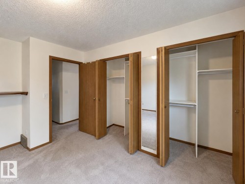 Bedroom featuring light-toned carpet flooring, white walls, and wood trim - 4005 55 Avenue, Whitecourt, AB - Indoor