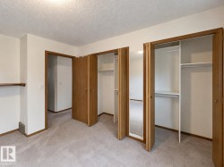 Bedroom featuring light-toned carpet flooring, white walls, and wood trim - 