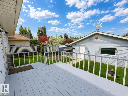 Spacious outdoor deck featuring gray wood-finish flooring and white railings - 4005 55 Avenue, Whitecourt, AB - Outdoor With Deck Patio Veranda With Exterior