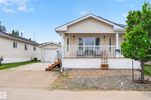 Single-story residence featuring light-colored siding and a covered front porch with white railing - 1727 Jubilee Loop, Sherwood Park, AB - Outdoor With Deck Patio Veranda