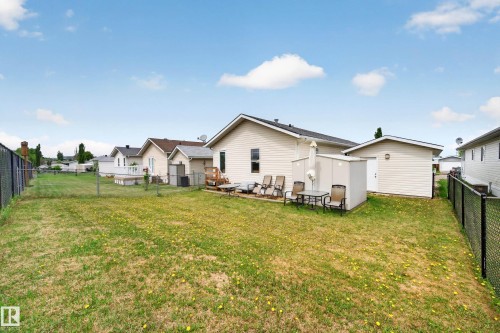 Spacious backyard featuring a chain-link perimeter fence, a detached auxiliary building, and a dedicated patio area - 1727 Jubilee Loop, Sherwood Park, AB - Outdoor