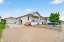 Cream-colored siding exterior featuring a covered front porch with white railings and wood-finish steps - 1727 Jubilee Loop, Sherwood Park, AB  - Outdoor With Deck Patio Veranda 