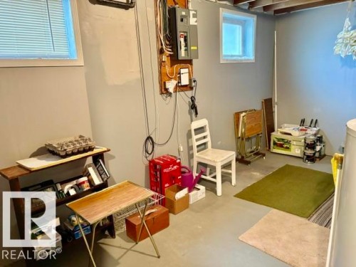 Utility basement area featuring painted concrete flooring and two high-set windows - 5454 46 Street, Vegreville, AB - Indoor
