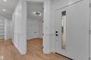 Entryway featuring a white door with vertical glass insert, matte black hardware, and light wood-finish flooring - 2027 156 Avenue, Edmonton, AB  - Indoor Photo Showing Other Room 