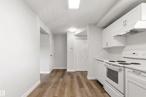 Kitchen featuring wood-finish flooring, white cabinetry, a white electric range, and a white dishwasher - 707 Clareview Road, Edmonton, AB - Indoor Photo Showing Kitchen